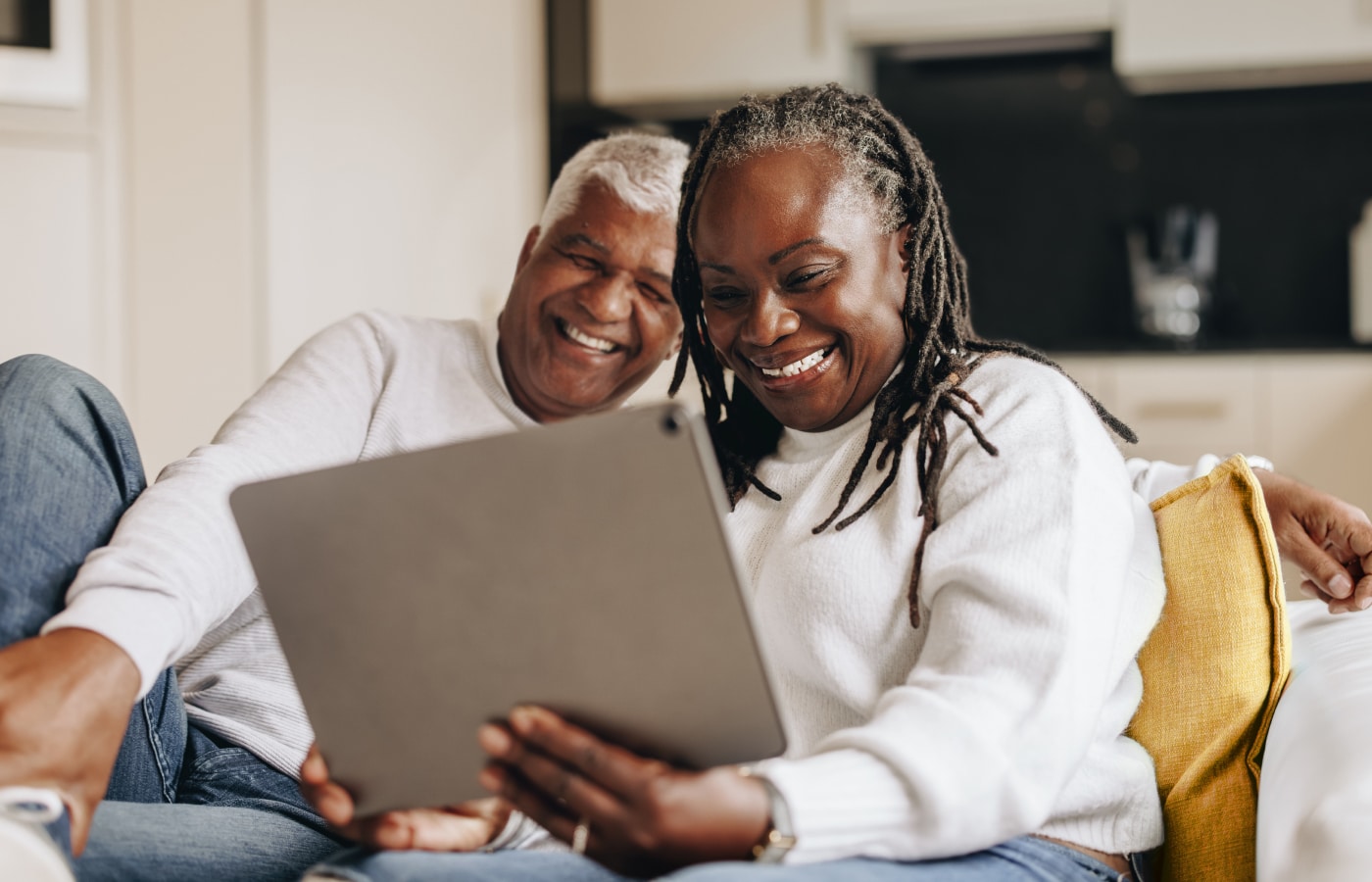 Couple sitting on couch watching video on laptop