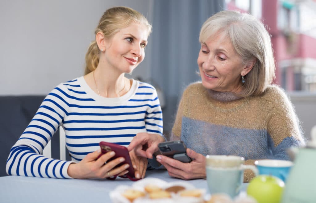 Mother and daughter looking at files on smartphone